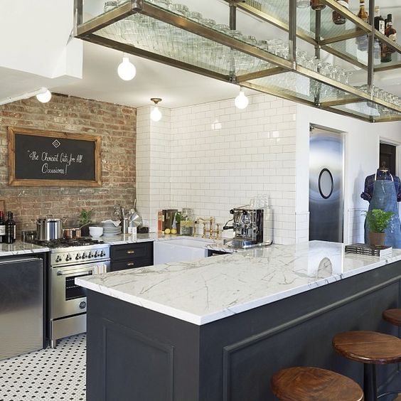 Love this kitchen. Brick wall, tile floor, open rack above for glasses. Similar to a bar great for a college brownstone.